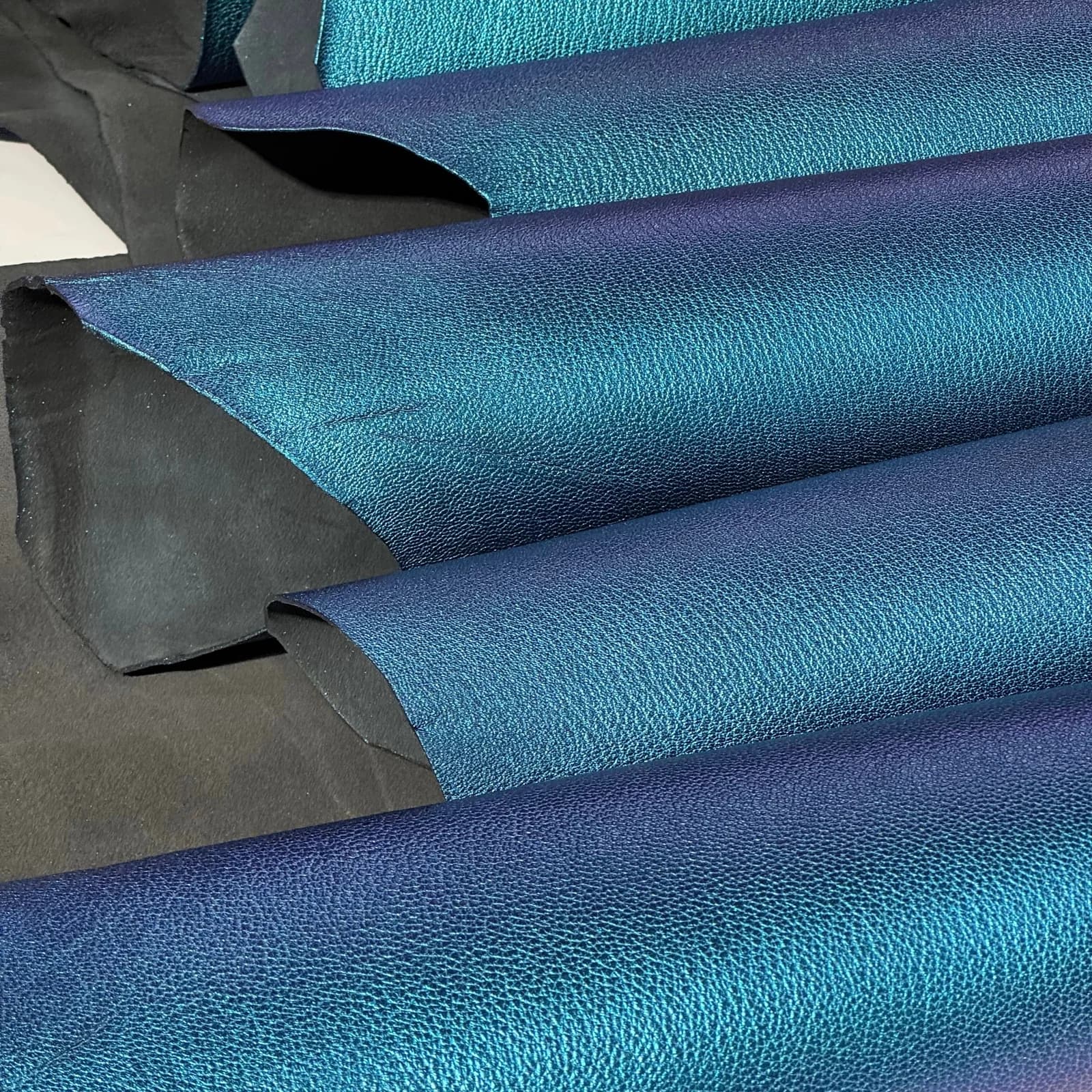 Rolled leather hides in blue and teal colors