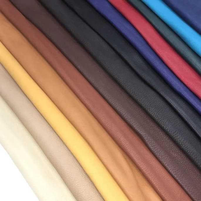 Stacked buckskin hides in natural and dyed colors