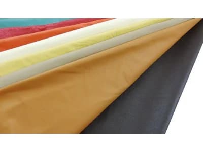 A whole tan upholstery leather hide laid flat on a white field