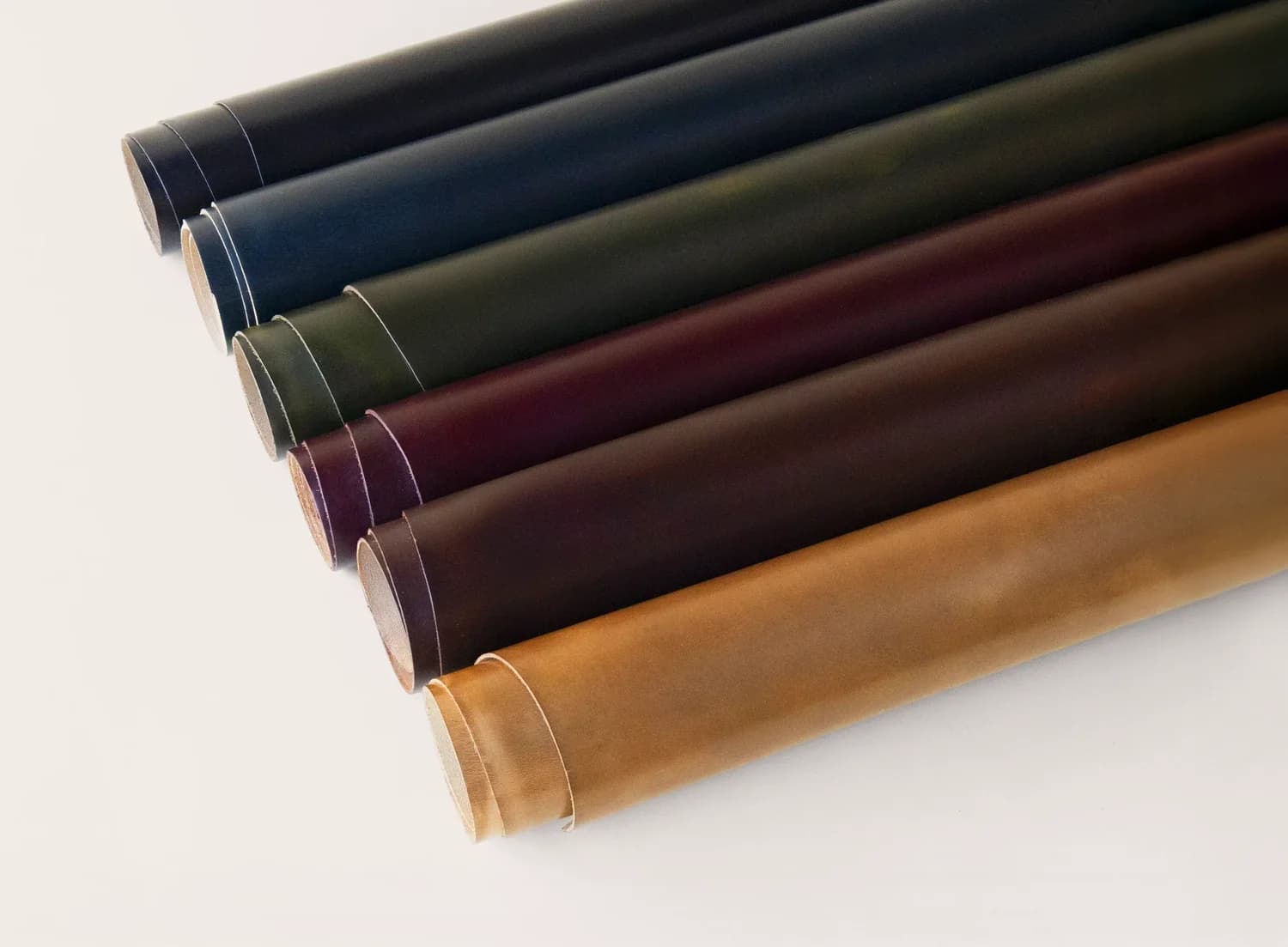 Rolled sides of Horween Chromexcel leather showing rich brown pull-up colors