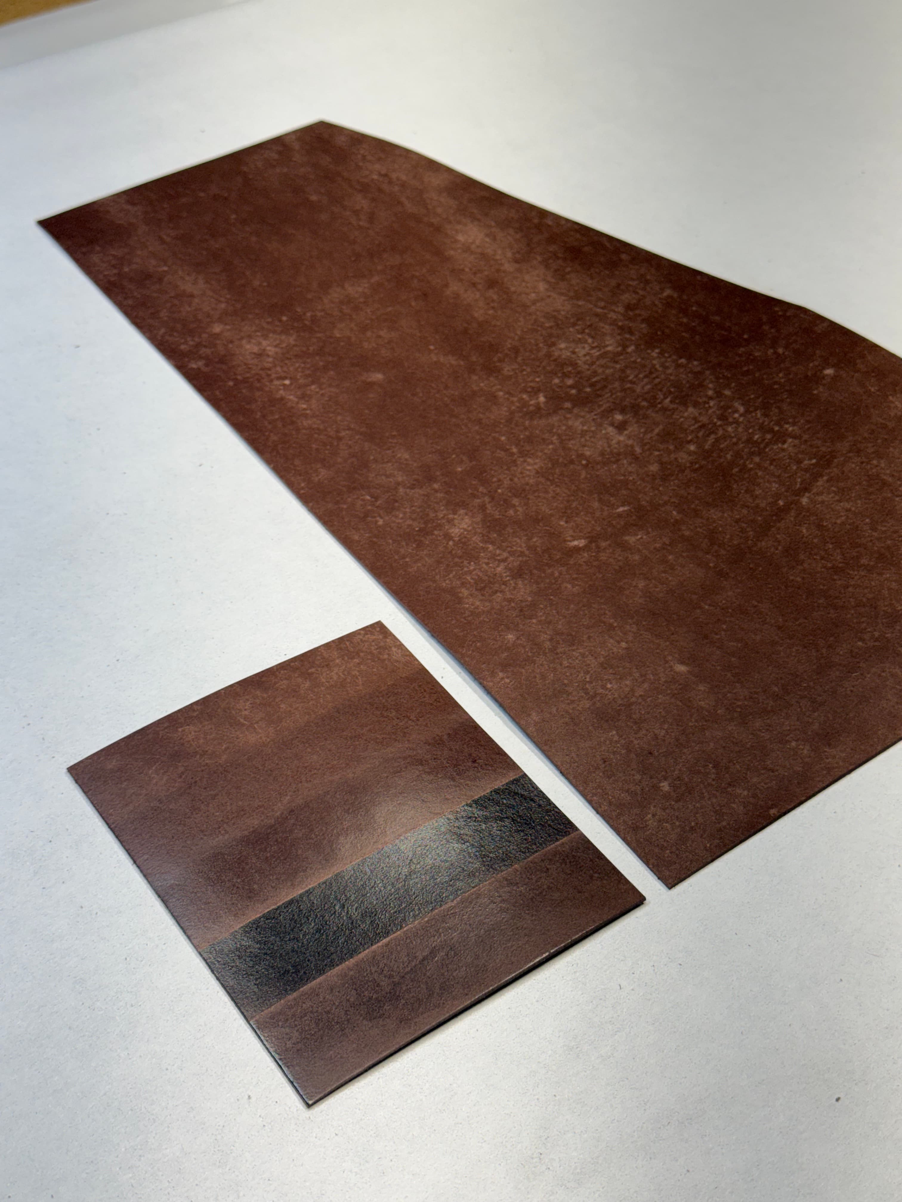The same five-band treatment sample beside untreated Maya, viewed at an angle that reveals different levels of sheen.