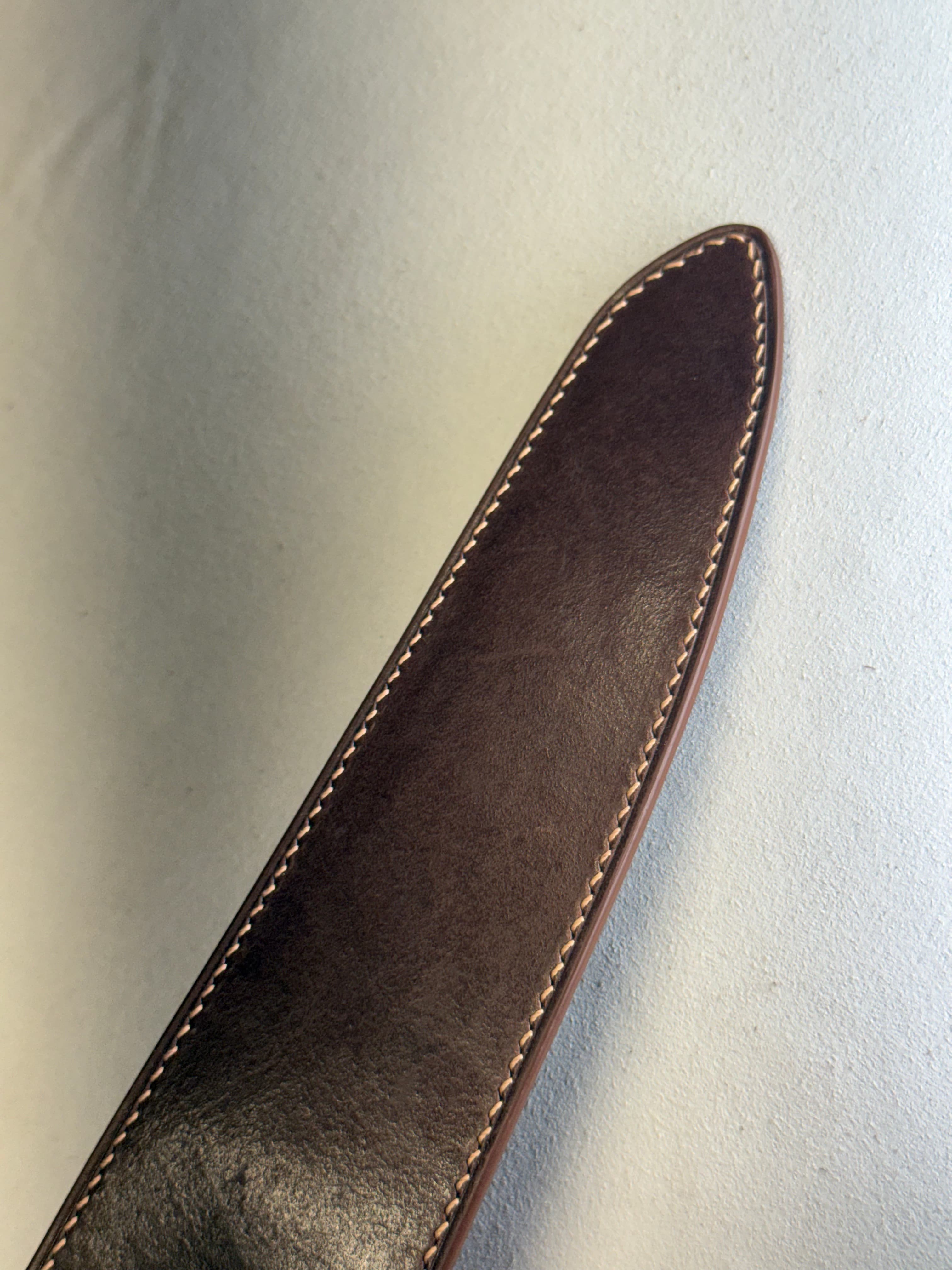 A darker view of the Tokonole-finished sheath, with mottled walnut tones and a broad reflective patch near the lower end.