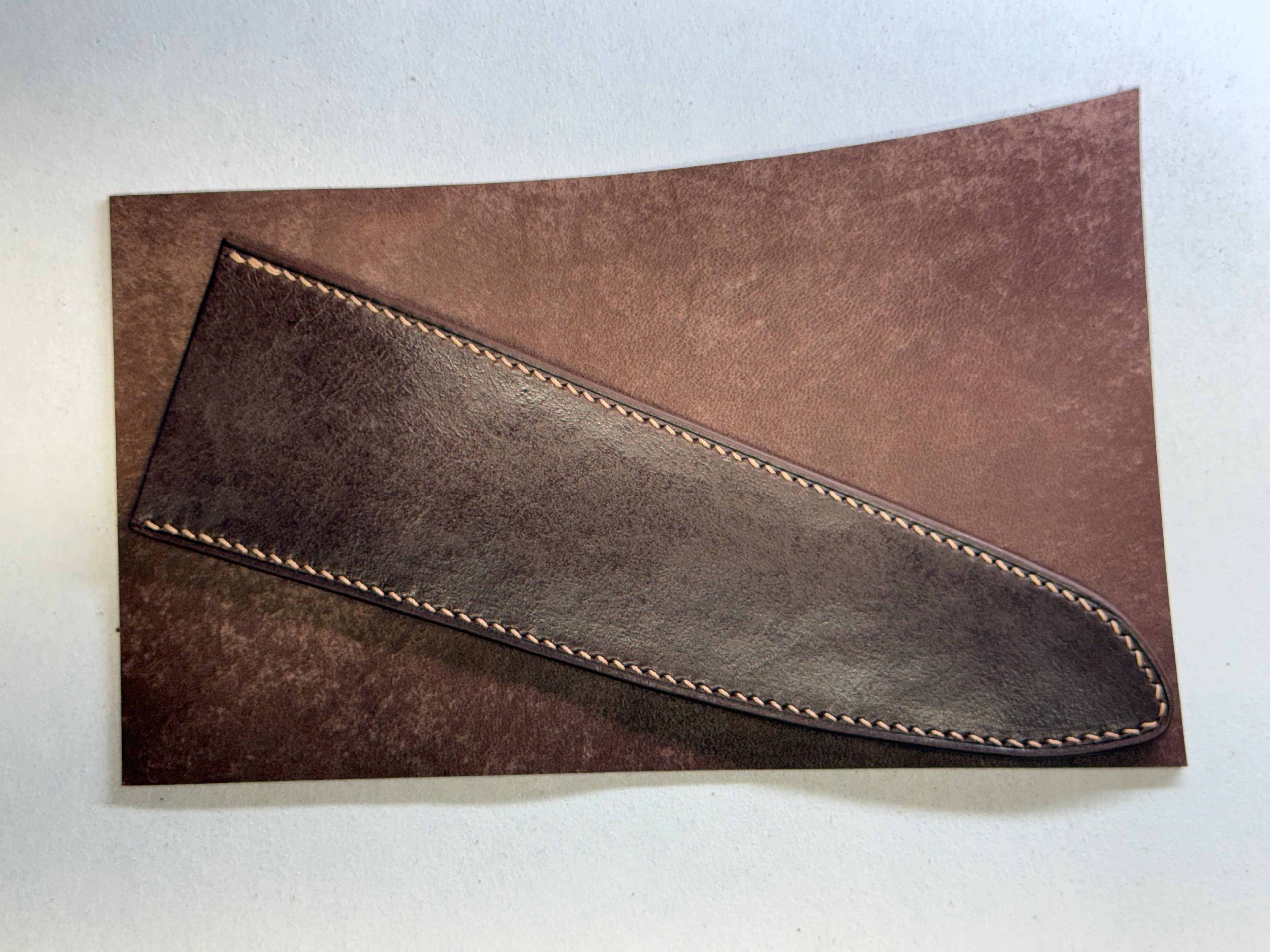 The completed dark Tokonole-treated sheath laid diagonally across a lighter, untreated Maya panel.